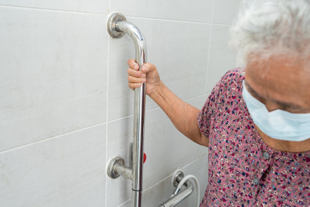 Asian senior or elderly old lady woman patient use toilet bathroom handle security in nursing hospital ward, healthy strong medical concept.の写真素材