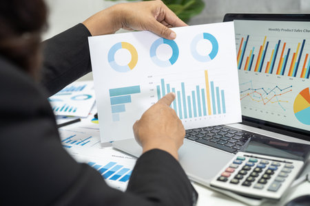 Asian accountant working and analyzing financial reports project accounting with chart graph and...