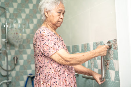 Asian senior or elderly old lady woman patient use toilet bathroom handle security in nursing hospital ward, healthy strong medical concept.の写真素材