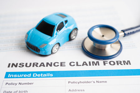 Stethoscope on Insurance claim accident car form, Car loan, insurance and leasing time concepts.の写真素材
