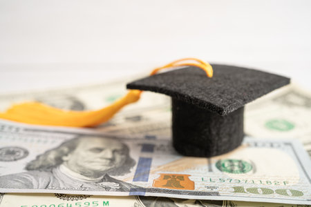 Graduation gap hat on US dollar banknotes money, Education study fee learning teach concept.の写真素材