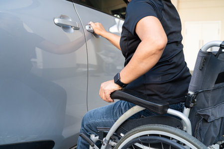 Asian woman folding and lift up wheelchair into her car. Accessibility concept.の写真素材