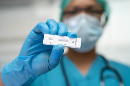 Asian doctor in PPE suit show positive test result with Saliva Antigen Test Kit for check Covid19...