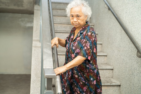 Asian senior or elderly old lady woman patient use slope walkway handle security with help support assistant, healthy strong medical concept.の写真素材