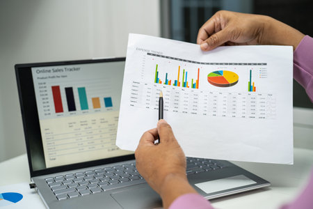 Asian accountant working and analyzing financial reports project accounting with chart graph in...