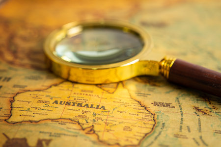 Bangkok, Thailand January 20, 2022 Australia, Magnifying glass close up with vintage old antique world map, travel, geography, tourism and exploration concept.のeditorial素材