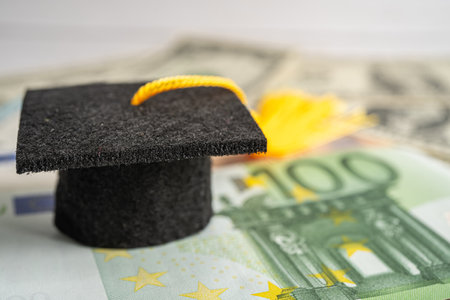 Graduation gap hat on Euro and US dollar banknotes money, Education study fee learning teach concept.の写真素材