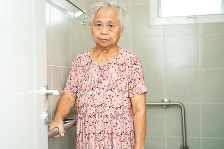Asian senior or elderly old lady woman patient use toilet bathroom handle security in nursing hospital, healthy strong medical concept.の写真素材