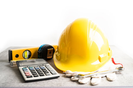 Architectural house plan project blueprint and yellow helmet with calculator, engineer construction tools.の写真素材
