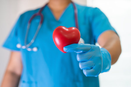 Doctor holding a red heart in hospital ward, healthy strong medical concept.の写真素材