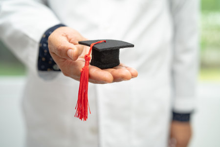 Asian doctor study learn with graduation gap hat in hospital ward, clever bright genius education medicine concept.の写真素材