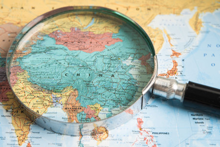 Bangkok, Thailand  January 20, 2022 China, Magnifying glass close up with colorful world map, travel, geography, tourism and exploration concept.のeditorial素材