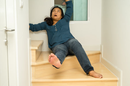 Asian lady fall down the stairs and pain at hip and waist because slippery surfaces.の写真素材