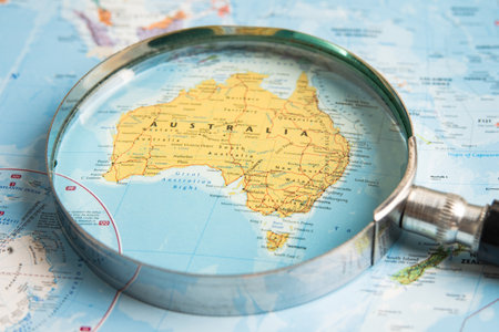 Bangkok, Thailand  January 20, 2022 Australia, Magnifying glass close up with colorful world map, travel, geography, tourism and exploration concept.のeditorial素材
