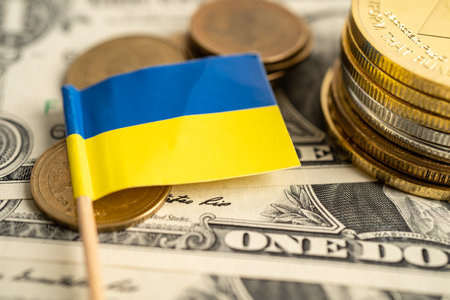 Stack of coins with Ukraine flag and US dollar banknotes.の写真素材