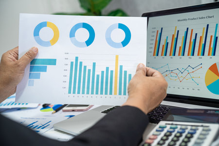Asian accountant working and analyzing financial reports project accounting with chart graph in...