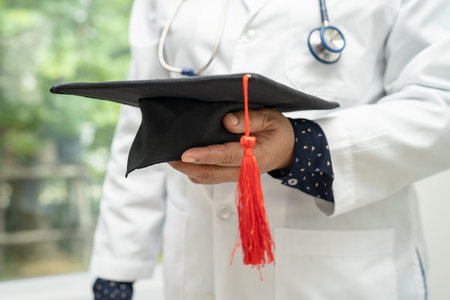 Asian doctor study learn with graduation gap hat in hospital ward, clever bright genius education medicine concept.の写真素材