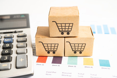 Shopping cart logo on box with magnifying glass on graph background. Banking Account, Investment Analytic research data economy, trading, Business import export transportation online company concept.の写真素材