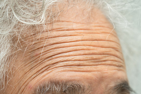 Asian elderly woman face and eye with wrinkles, portrait closeup view.の写真素材