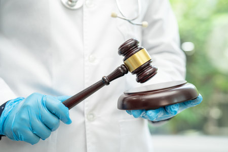 Doctor holding judge gavel, forensic medicine, medical law and crime justice concept.の写真素材