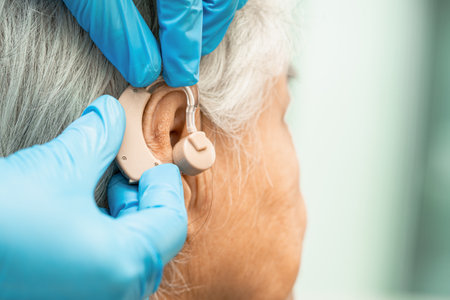 Asian senior woman patient wearing a hearing aid for treating hearing loss problem.の写真素材