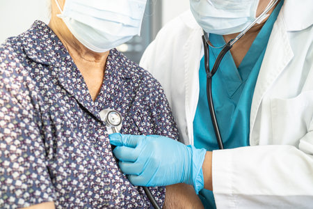 Doctor using stethoscope to checking the patient lie down on a bed in the hospital, healthy strong medical concept.の写真素材