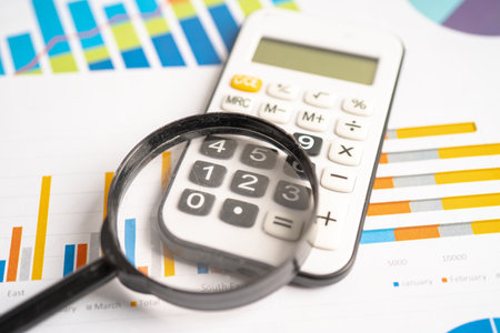 Calculator on chart graph paper. Finance, account, statistic, investment data economy, stock exchange business.の写真素材