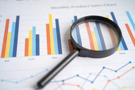 Magnifying glass on charts graphs paper. Financial development, Banking Account, Statistics,...