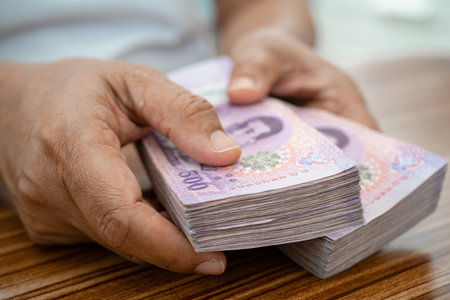 Asian business woman holding Thai banknote currency money.の写真素材