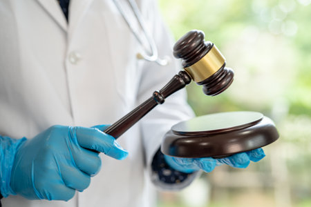 Doctor holding judge gavel, forensic medicine, medical law and crime justice concept.の写真素材
