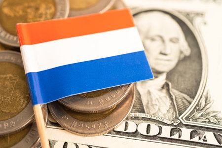 Stack of coins with Netherlands flag and US dollar banknotes.の写真素材