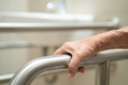 Asian elderly woman patient use toilet bathroom handle security in nursing hospital, healthy strong...