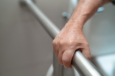 Asian elderly woman patient use toilet bathroom handle security in nursing hospital, healthy strong medical concept.の写真素材