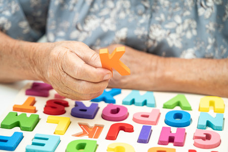 Alzheimer disease AD, Asian elderly woman patient suffering from dementia learn practical motor skills rehabilitation.の写真素材