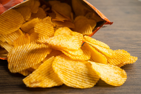 Potato chips, delicious BBQ seasoning spicy for crips, thin slice deep fried snack fast food in open bag.の写真素材
