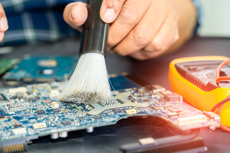 Asian technician repair and cleaning dirty micro circuit main board of smartphone electronic technology with brush, hardware, mobile phone, upgrade concept.の写真素材