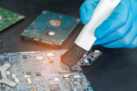 Asian technician repair and cleaning dirty micro circuit main board of smartphone electronic...