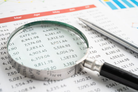 Magnifying glass on spreadsheet and graph paper. Financial development, Banking Account, Statistic, Investment Analytic research data economy, Business.の写真素材