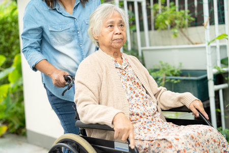 Caregiver help and care Asian senior woman patient sitting on wheelchair to ramp in nursing hospital, healthy strong medical.の写真素材