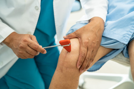 Asian doctor use hammer knock senior woman patient to check knee reflex, nerve and muscle in hospital.の写真素材