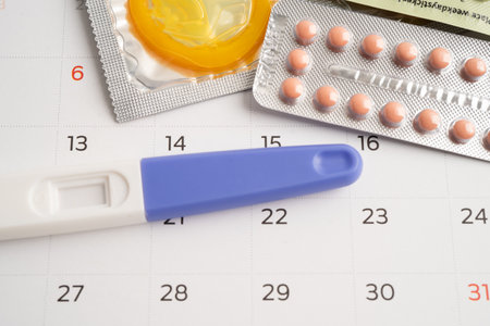 Pregnancy test and birth control pills on calendar, contraception health and medicine.の写真素材