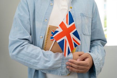 Learn English language, Asian teenage student hold book with flag in course at school.の写真素材