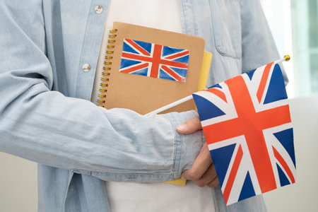 Learn English language, Asian teenage student hold book with flag in course at school.の写真素材