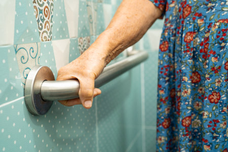 Asian elderly woman patient use toilet bathroom handle security in nursing hospital, healthy strong medical.の写真素材