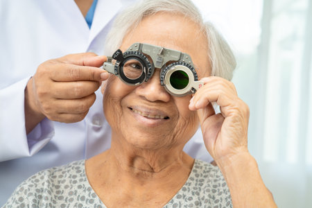 Asian senior woman wearing ophthalmic vision eye test and using optical trial frame.の写真素材