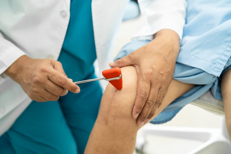 Asian doctor physiotherapist examining, massaging and treatment knee and leg of senior patient in orthopedist medical clinic nurse hospital.の写真素材