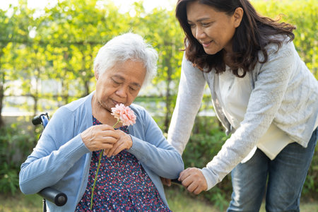 Asian senior woman holding flower, smile and happy in the garden.の写真素材