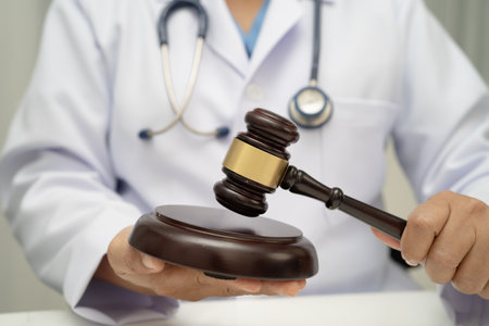 Doctor holding judge gavel, forensic medicine, medical law and crime justice.の写真素材