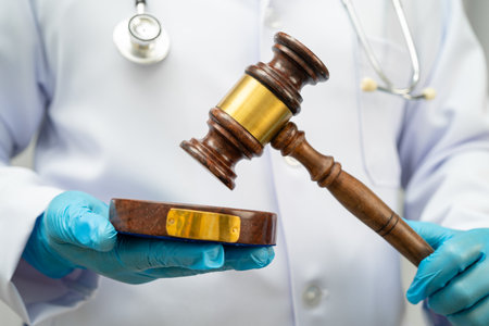 Doctor holding judge gavel, forensic medicine, medical law and crime justice.の写真素材
