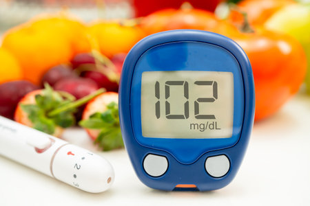 Asian hand holding digital glucose monitor measure with vegetable and fruit healthy food.